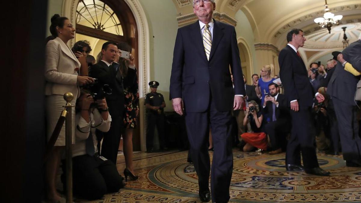 Senate Majority Leader Mitch McConnell of Ky., center, approaches the podium to talk to reporters on Capitol Hill in Washington, Tuesday, July 25, 2017, after Vice President Mike Pence broke a 50-50 tie to start debating Republican legislation to tear down much of the Obama health care law.