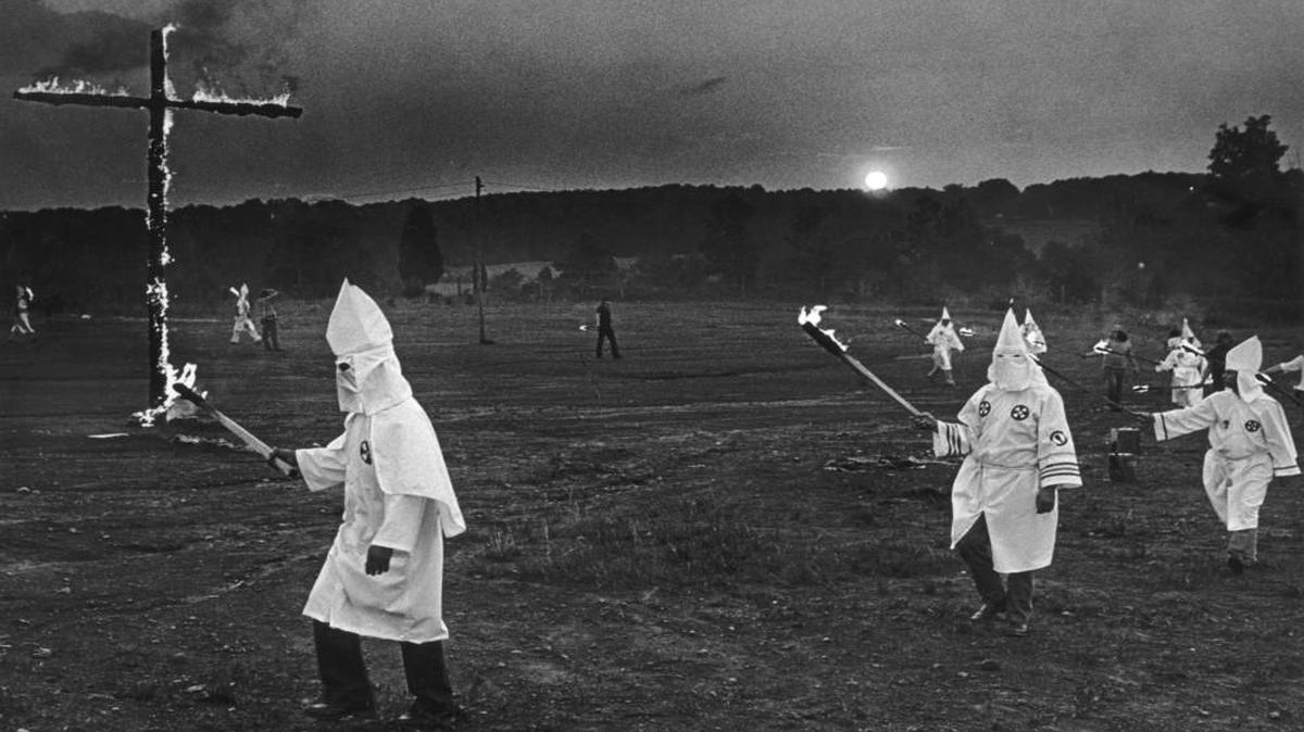 Ku Klux Klansmen circle a flaming cross at a KKK rally near Lincolnton, N.C. in late 1979 shortly after a Greensboro shootout between members of the KKK and American Nazi Party and members of the Communist Workers' Party. Four members of the CWP and one other person were killed and 10 people were wounded. At least two of the Klansmen charged in the shooting attended this rally.