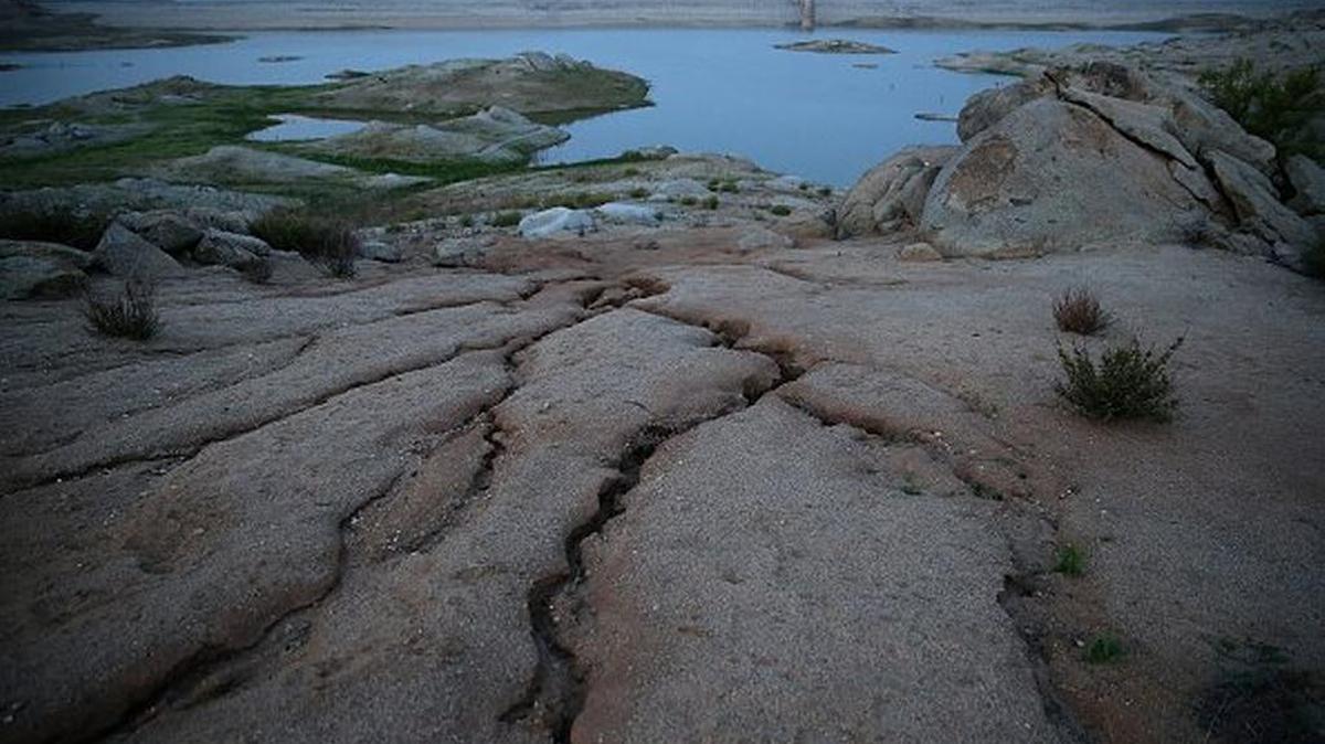 The earth cracked up with dryness in the fourth year of California’s drought at Hensley Lake on April 23, 2015 in Raymond, California. A federal report warns that increasing temperatures are decreasing soil moisture in California, compounding impacts of droughts.