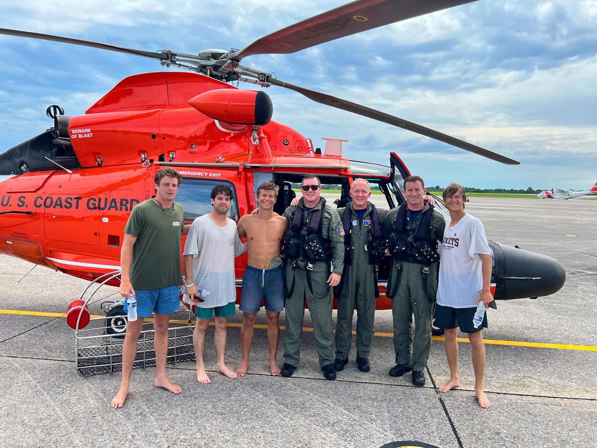 This photo shows the rescuers and the four boaters who were airlifted from the water after their boat capsized off Alabama.