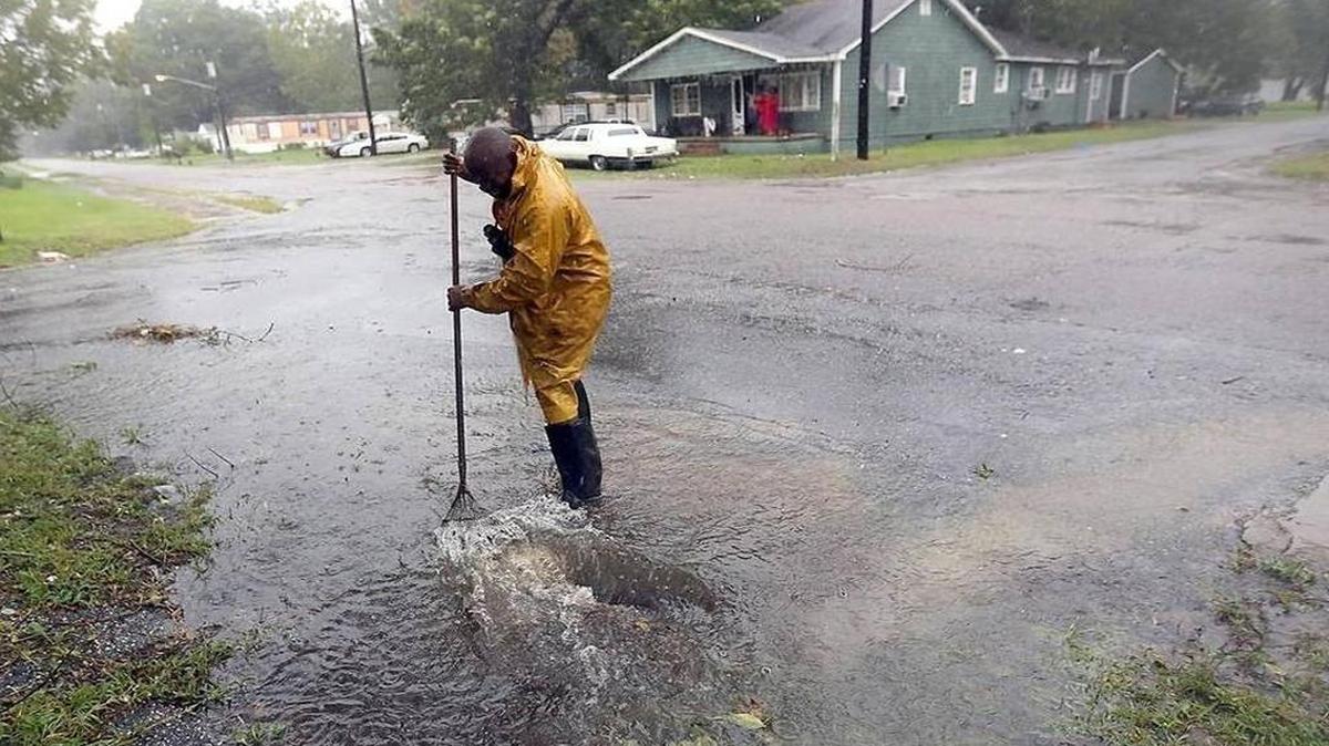 Tony Vanverhorst cleans a drain off Merriman Road in Georgetown on Saturday, Oct. 8, 2016. The city was bracing as Hurricane Matthew came up the East Coast as a category one.