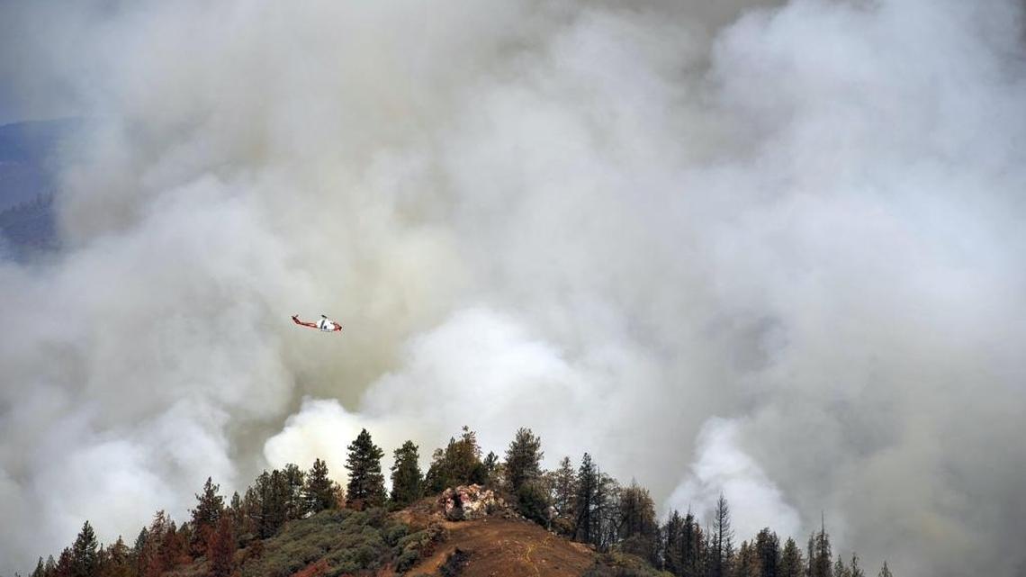A United States Forest Service Cobra helicopter flies over the burn-out operation along McKenzie Ridge Saturday, September 19, 2015 near Kings Canyon National Park, Calif.