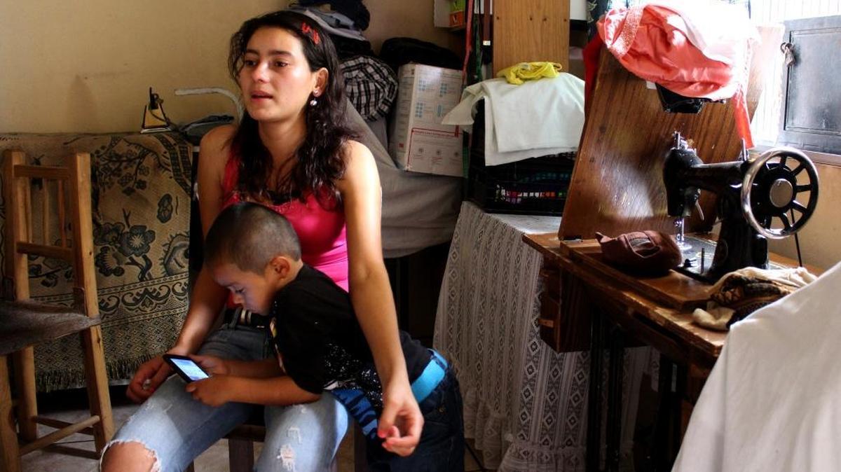 
Lilian Oliva Bardales, aged 19, sits while her son, Christian, aged 4, plays with her mobile phone in the small living room at a relative's house in a community of Tegucigalpa, Honduras on June 15, 2015. Oliva and her son fled Honduras last week and are now living in Western Europe.
