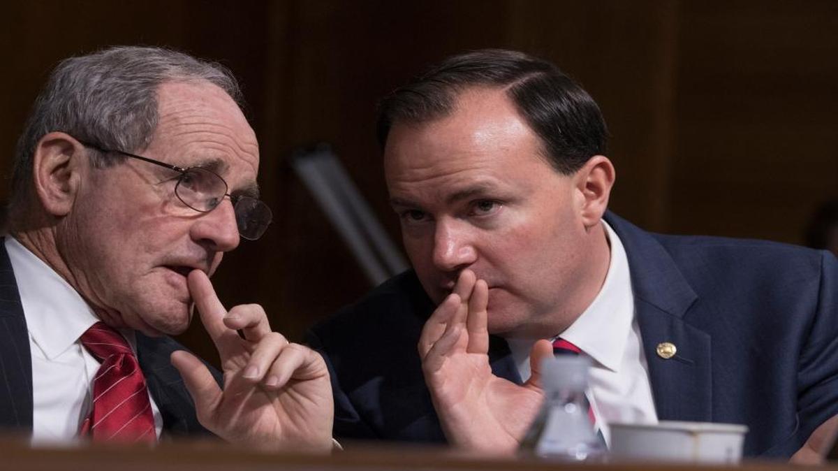 Senate Energy and Natural Resources Committee members Sen. Jim Risch, R-Idaho, left, and Sen. Mike Lee, R-Utah, confer on Capitol Hill in Washington on Jan. 17, 2017.