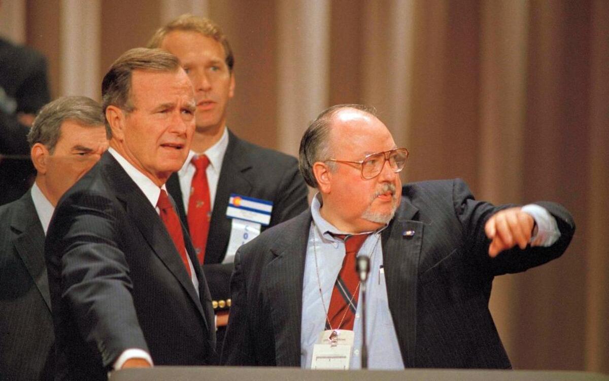 In this Aug. 17, 1988 file photo, Vice President George H.W. Bush, left, gets some advice from his media advisor, Roger Ailes, right, as they stand behind the podium at the Superdome in New Orleans, La., prior to the start of the Republican National Convention.