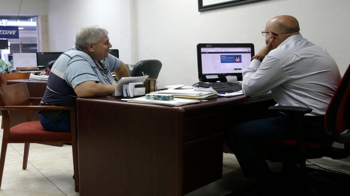 Sami Jamaleddine, left, signs up for health insurance offered under the Affordable Care Act with insurance agent Michael Khoury, right, in Miami. Health insurers, hospitals and other groups are calling for the Trump administration to pay roughly $7 billion in federal subsidies this year to help low-income plan enrollees with out-of-pocket costs.