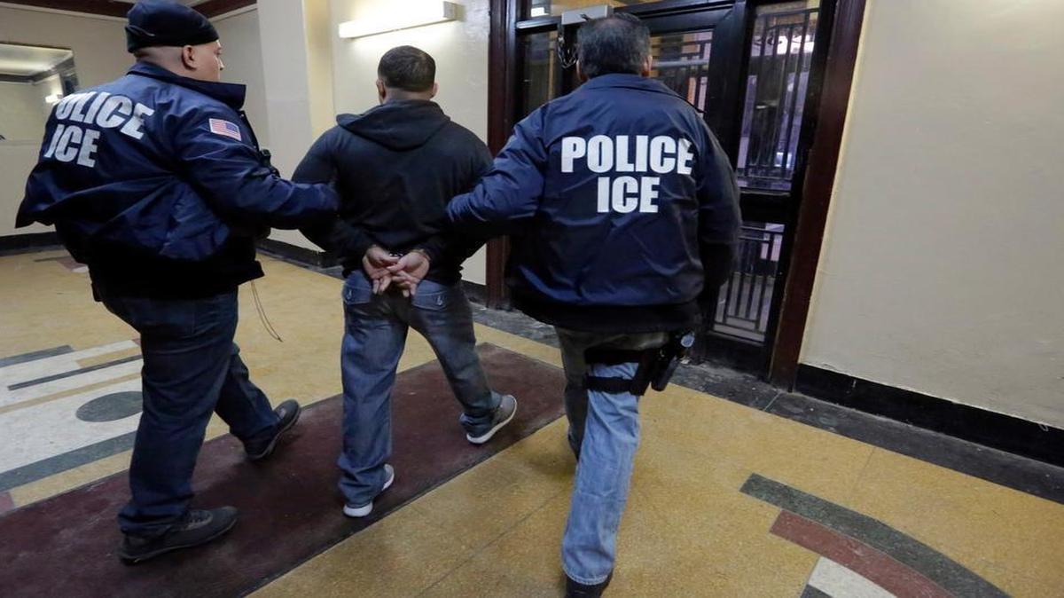 The nation’s highest immigration court has blocked the deportations of a handful of families who were apprehended as part of an effort to combat illegal immigration. In this March 3, 2015 photo, Immigration and Customs Enforcement officers escort a detainee in an apartment building in the Bronx borough of New York during a series of early-morning raids.
