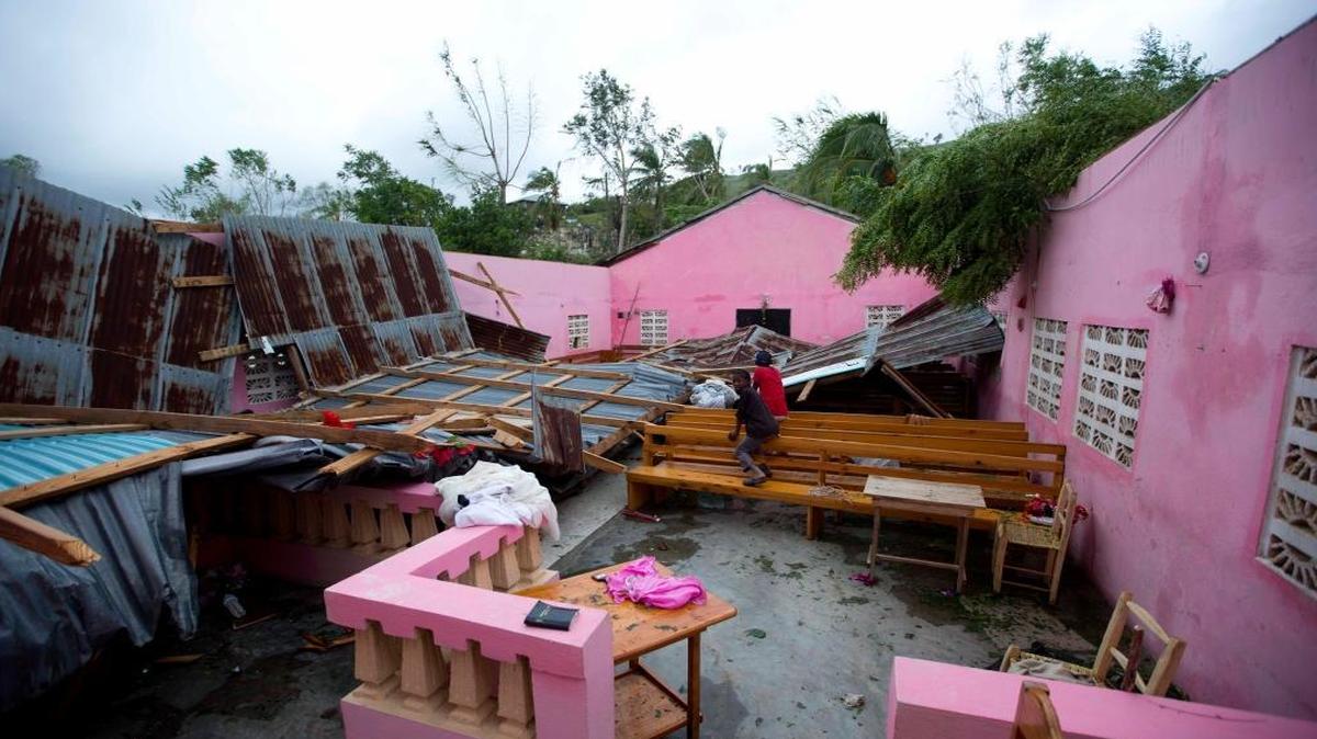 Children sit inside a church damaged by Hurricane Matthew in Saint-Louis, Haiti, Wednesday, Oct. 5, 2016. President Barack Obama is asking U.S. citizens to help as rescue workers in Haiti struggle to reach cutoff towns and learn the full extent of the death and destruction.