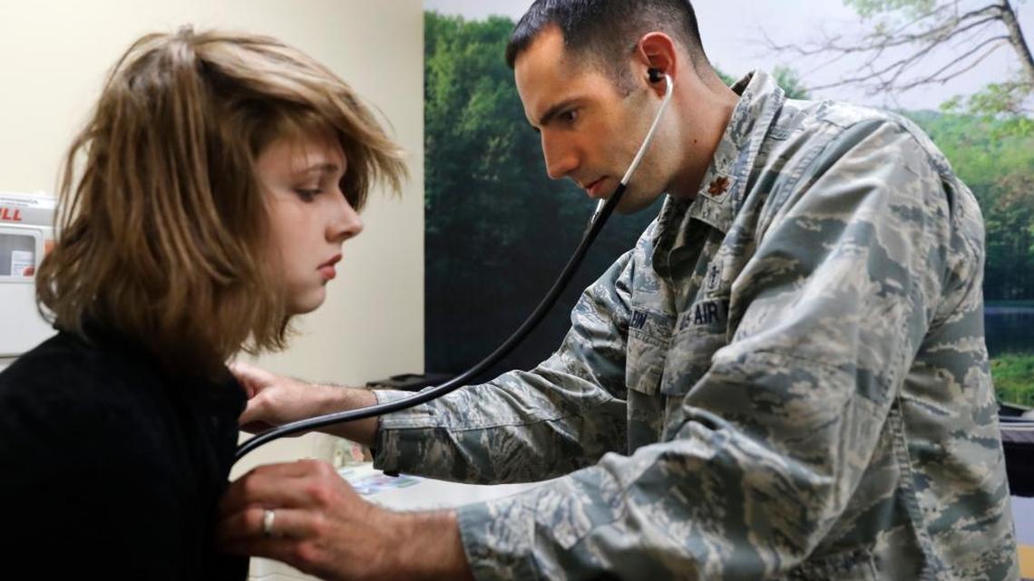 In this Sept. 7, 2016, photo, Dr. David Klein, chief of adolescent medicine at Fort Belvoir Community Hospital and an Air Force Major, listens to the heartbeat of Jenn Brewer, 13, at her monthly doctors appointment visit for monitoring of her treatment at the Pediatric Clinic at Fort Belvoir Community Hospital in Fort Belvoir, Va. Brewer is transitioning from male to female.