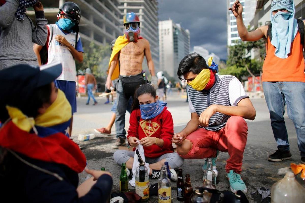 Anti-government demonstrators prepare homemade petrol bombs during a protest Friday against the installation of a national constituent assembly in Caracas.