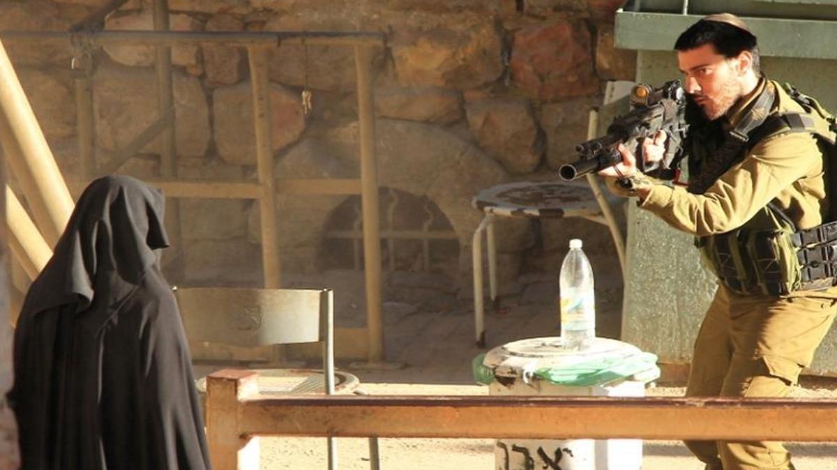 
An Israeli soldier takes aim at a Palestinian woman at a checkpoint in Hebron. The photo was made available by the Youth Against Settlements, a Palestinian activist network the opposes Jewish settlements in the West Bank. 
