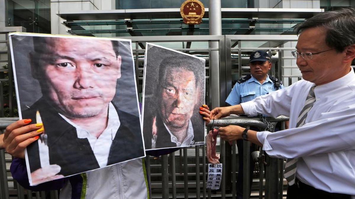 
Anti-Beijing protesters in Hong Kong held pictures of human rights lawyer Pu Zhiqiang in May. Pu is among the prominent human rights lawyers who’ve been detained in recent months.
