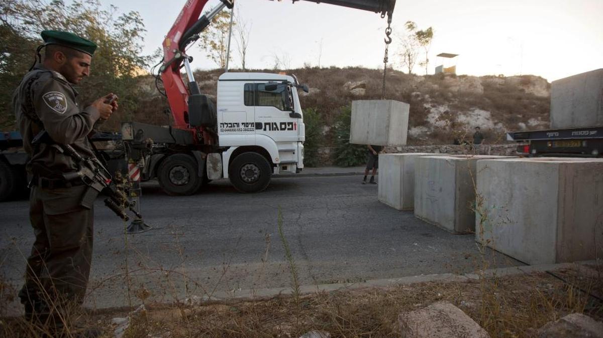 
Workers placed concrete blocks on the road at the entrance to the East Jerusalem neighborhood of Jabal Mukaber on Wednesday. The move, aimed at stopping a wave of knifings of Jews by Palestinians, has raised questions about whether Jerusalem is a united city.
