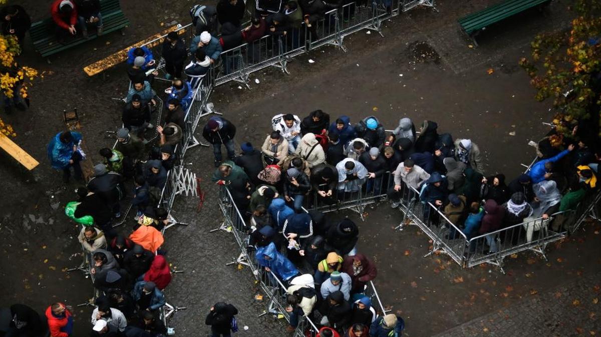 Migrants wait for their registration outside the main office of the State Office of Health and Welfare in Berlin, Germany. The influx of refugees from Syria and elsewhere has prompted postings on Facebook that many feel violates German laws against hate speech.