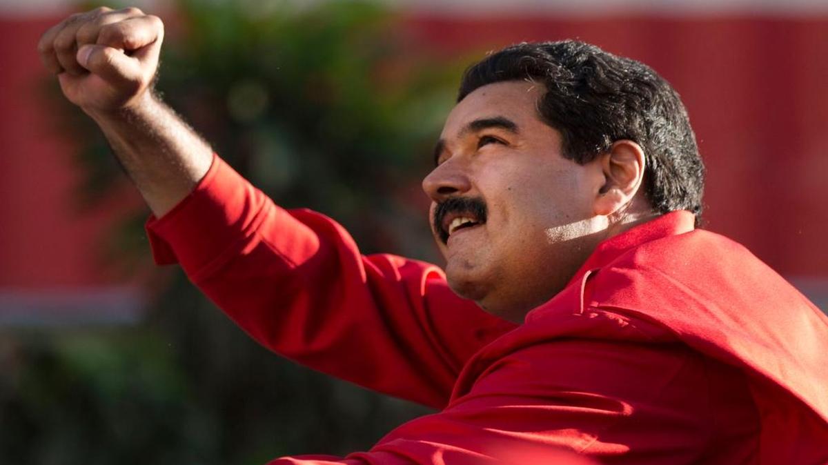 In this Dec. 1, 2015, photo, Venezuela’s President Nicolas Maduro gestures to supporters from the top of a car after the inauguration of a cable car public transportation system, in the popular neighborhood of Petare, in Caracas, Venezuela.