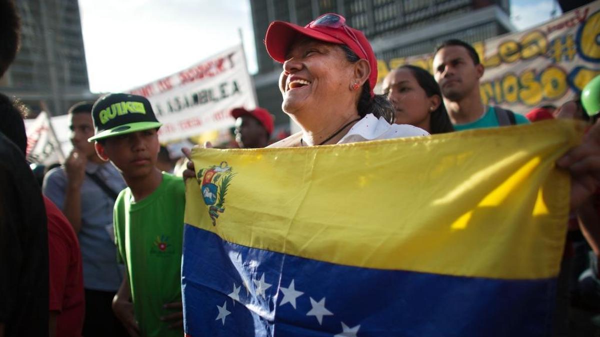 A government supporter holds a representation of Venezuela's national flag during a closing campaign for the ruling socialist party in Caracas, Venezuela, Friday, June 26, 2015. The PSUV, the Spanish acronym for the United Socialist Party of Venezuela, will hold nationwide primaries Sunday to select candidates for the upcoming December legislative elections.