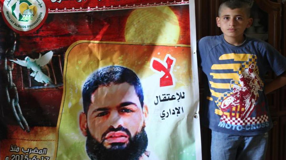 In the West Bank village of Ainabus, three of the 37 nephews of Mohammad Allan hold up a poster in to support his hunger strike in protest of incarceration in Israel without charges on August 19, 2015. Israel released Allan Wednesday after doctors said he may have suffered irreversible damage during his 65 days of fasting.