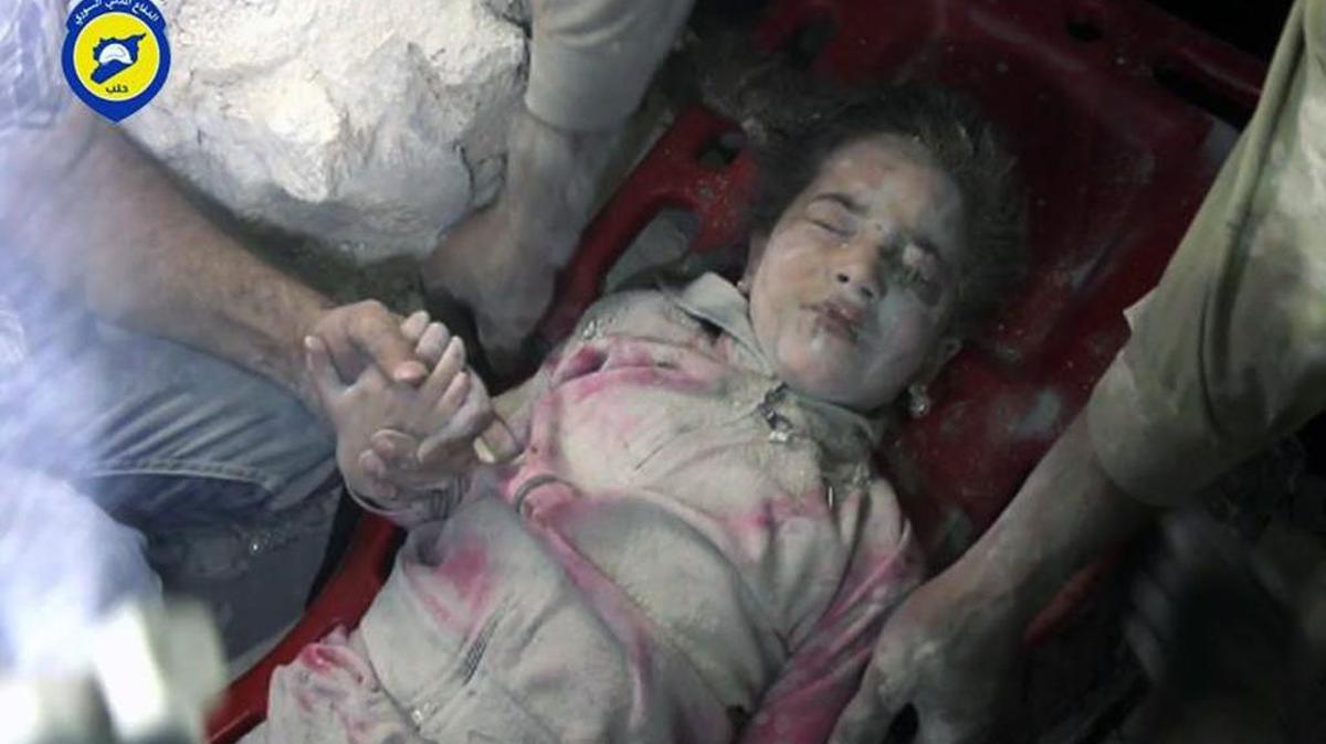 In this photo provided by the Syrian Civil Defense group known as the White Helmets, shows survived child Ghazal Akhtarini, carried by Civil Defense workers from under the rubles after airstrikes hit al-Shaar neighborhood in Aleppo, Syria.