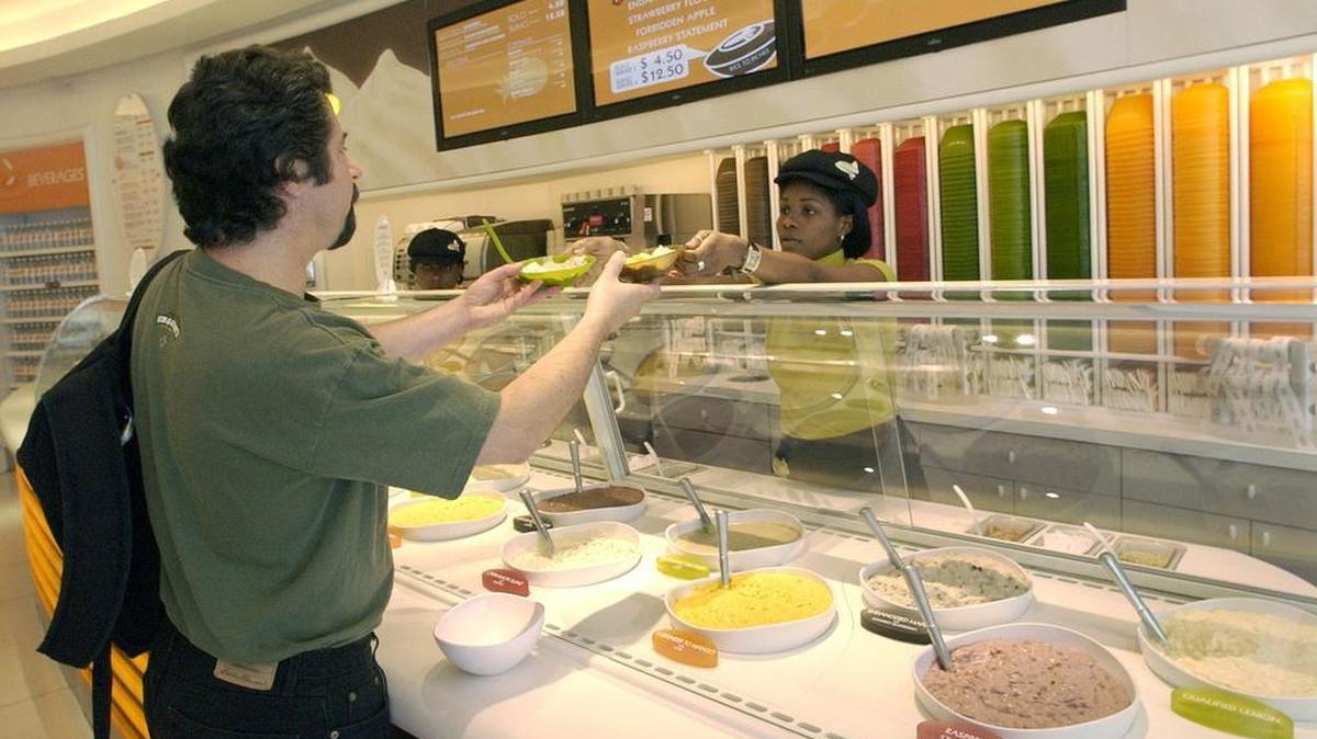It's rice pudding time for Arnold Carbone, director of research and development for Ben & Jerry's, buying a serving of rice pudding to taste flavors offered at Rice to Riches in New York City, Tuesday, July 1, 2003.