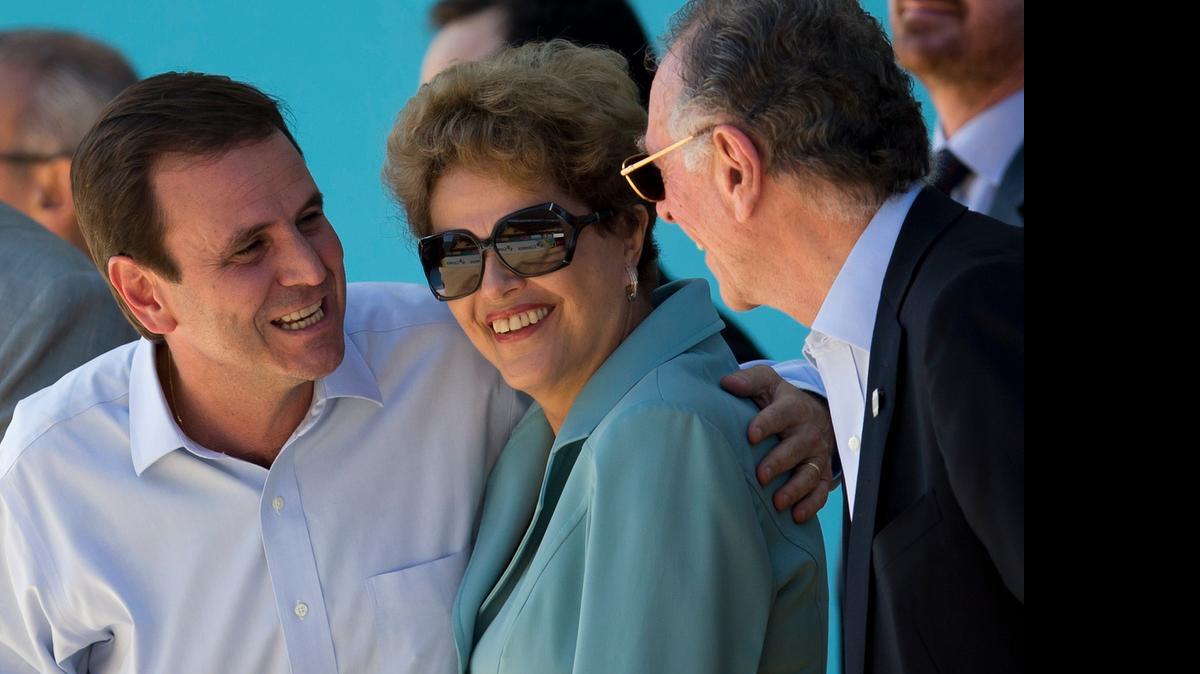 
Brazil's President Dilma Rousseff stands between Rio de Janeiro Mayor Eduardo Paes, left, and Brazil's Olympic Committee President Carlos Arthur Nuzman, right, Tuesday, June 23, 2015. On Sunday, June 28, 2015, Rousseff arrives in the United States for a three-day visit, capped by a bilateral meeting on Tuesday with President Barack Obama at the White House. The two leaders are expected to discuss economic and trade issues, defense cooperation, education, and climate change.
