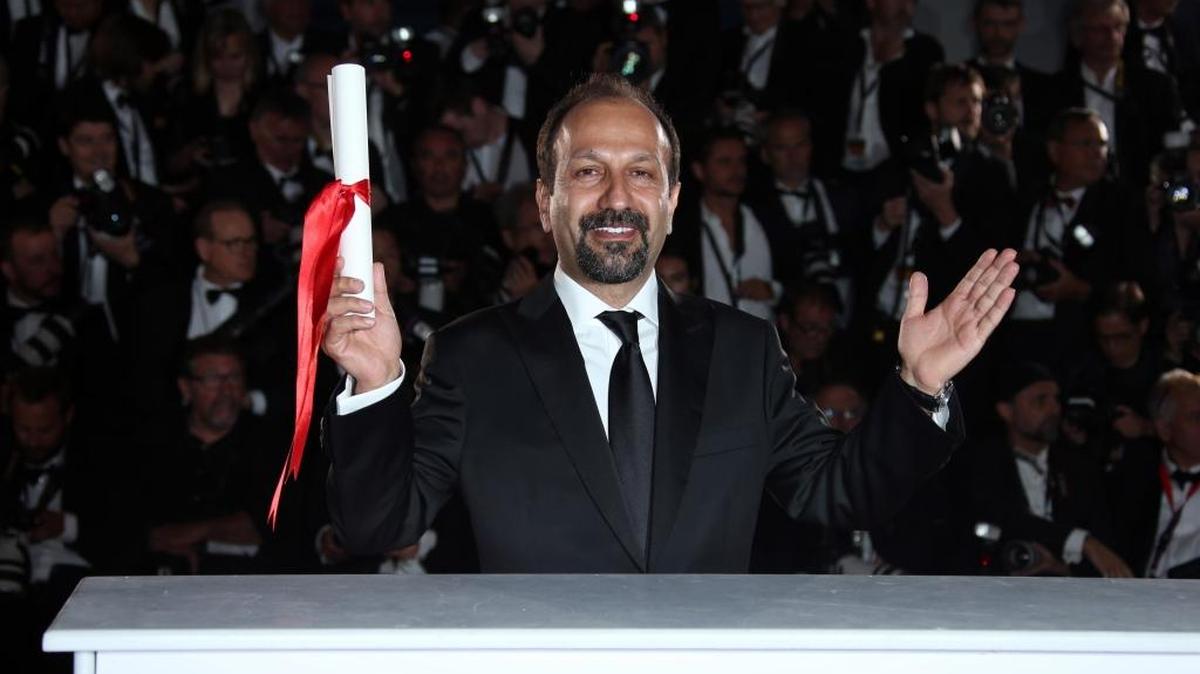 Director Asghar Farhadi poses for photographers after winning the Best Screenplay award for the film Forushande (The Salesman), during the photo call following the awards ceremony at the 69th international film festival, Cannes, southern France, Sunday, May 22, 2016.