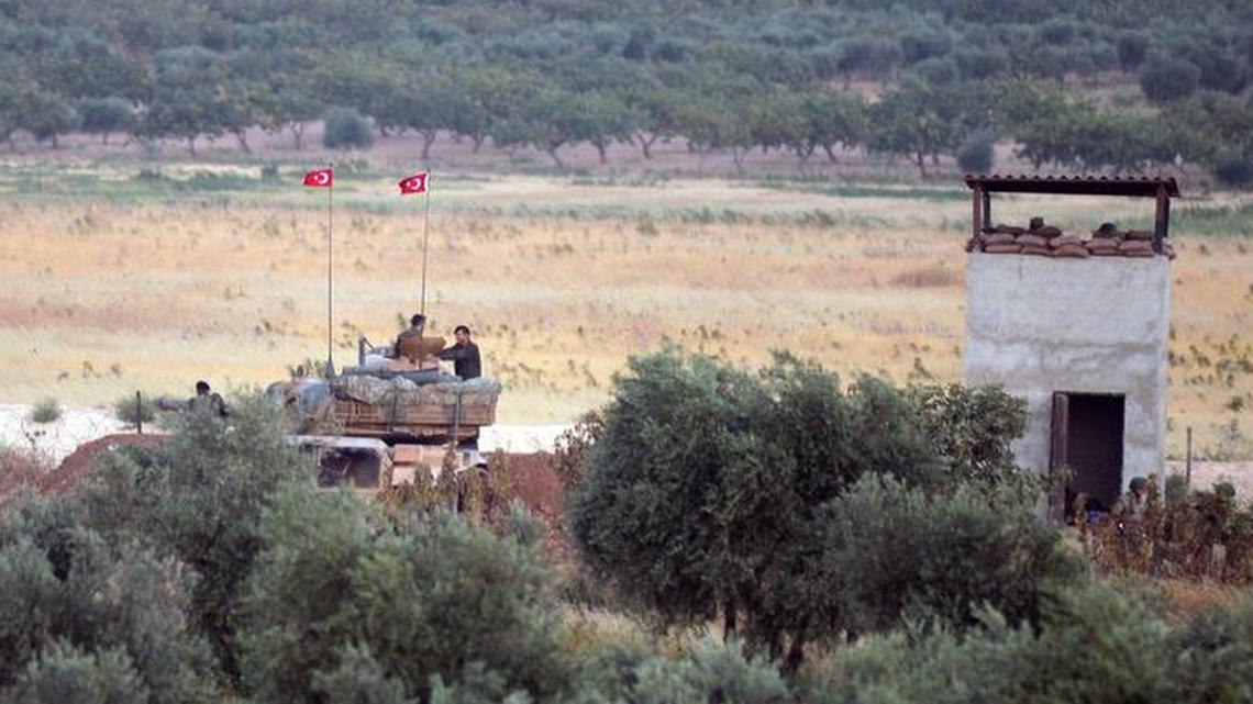 Turkish tanks and military vehicles take up positions Friday, July 24, 2015, near the village of Elbeyli-Ayyase near the border with Syria. The tanks were dispatched after Islamic State fighters killed a Turkish soldier nearby. Turkish airstrikes inside Syria killed the five Islamic State fighters responsible for the soldier's death, authorities said.