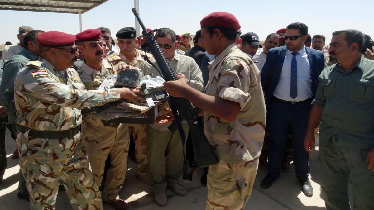 
A Sunni tribal volunteer (center right) receives a new U.S.-made weapon to fight Islamic State militants to regain Ramadi, in Habaniyah army base, 50 miles west of Baghdad, on Thursday, Sept. 3, 2015.
