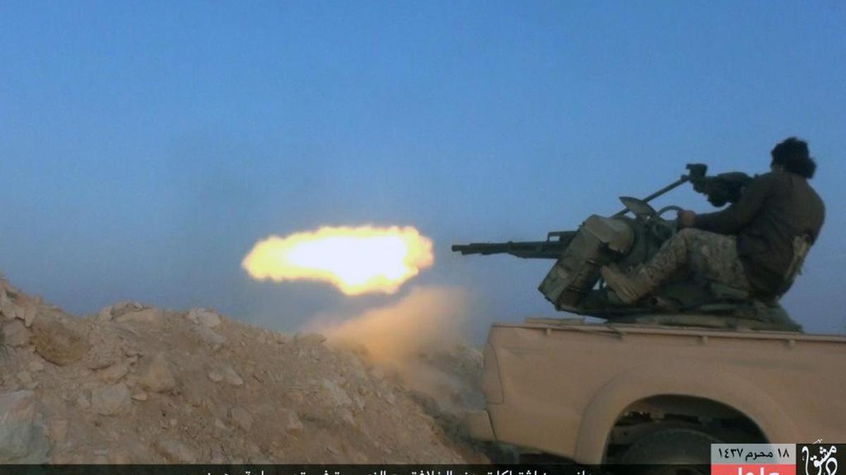 This image posted Sunday, Nov. 1, 2015, by a website used by Islamic State militants, shows an Islamic State fighter firing his weapon during a battle against Syrian government troops in the village of Mahin, central Homs province, Syria. The Islamic State said a suicide bomber attacked a Kurdish-led column of armored vehicles Sunday, including tanks and armored personnel carriers, killed dozens of Arabs and members of the Kurdish People’s Protection Units, or YPG.