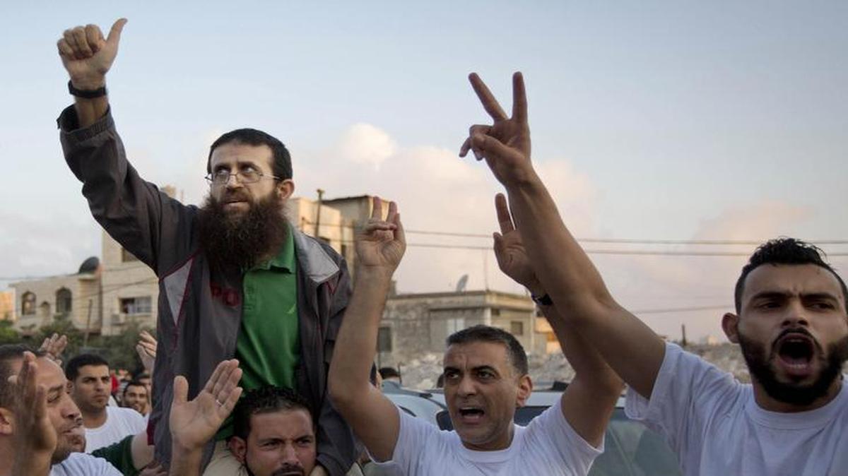 
In this July 12, 2015, file photo, Palestinian Khader Adnan, center, who recently ended a 55-day hunger strike, is greeted by Palestinians after his release from an Israeli prison in the West Bank village of Arrabeh near Jenin. Israel's parliament passed a contentious law on Thursday that would permit the force-feeding of inmates on hunger strike, eliciting harsh criticism over the practice.
