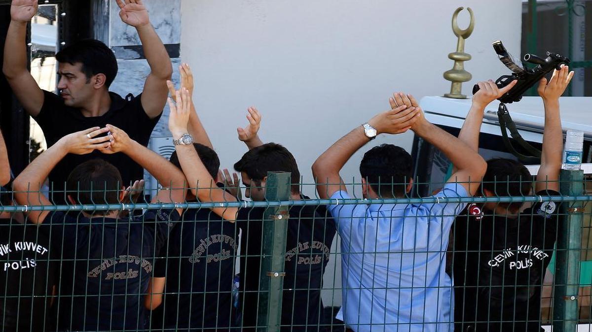 
Turkish police raise their arms to prevent photographers from capturing images of the coffins of two police officers found dead in their home Ceylanpinar, a town near Turkey’s border with Syria, Wednesday, July 22, 2015. )
