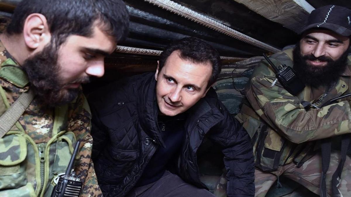 
Preserving in power Bashar Assad, shown here in a 2014 photos with Syrian troops, is the likely goal of the Russian intervention in Syria, experts say. 
