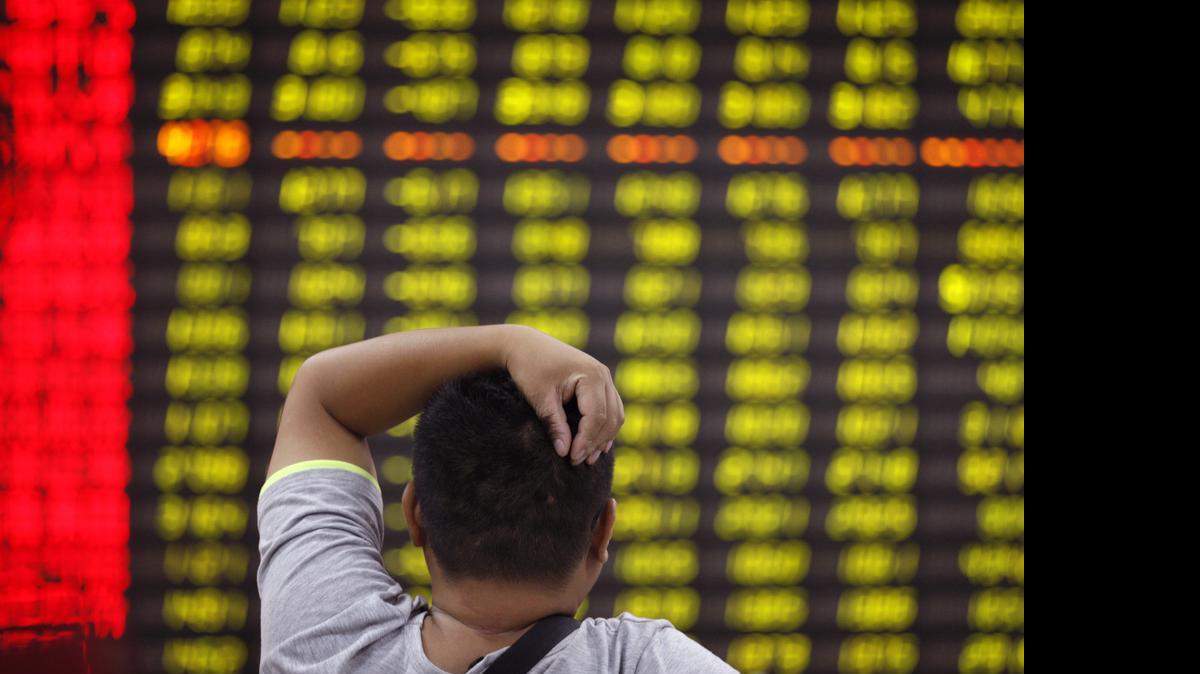 
An investor looks at a display of stock prices at a brokerage house in Huaibei in central China's Anhui province Friday, June 19, 2015. Shares pushed higher Friday despite a sell-off in China that pushed Shanghai's benchmark down 6.4 percent. 
