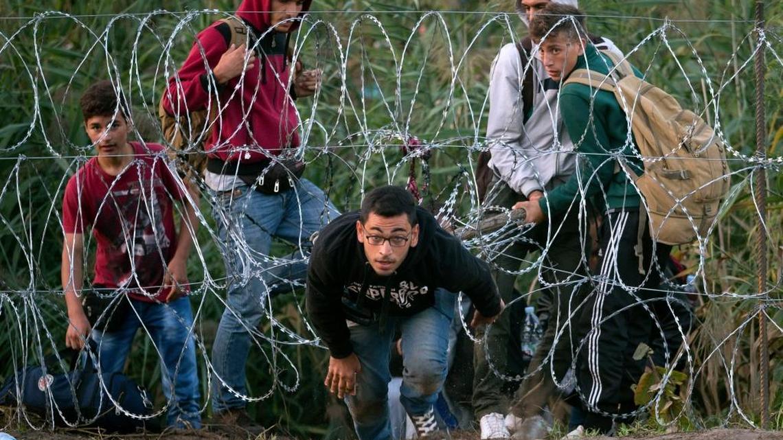 
A Syrian refugee runs after entering Hungary from Serbia through a barbed wire fence, on the border near Roszke, Friday, Aug. 28, 2015. Hungary deployed police reinforcements to rein in an unrelenting flow of migrants across its porous border Thursday, but refugee activists said the effort appeared futile in a nation whose migrant camps are overloaded and barely delay their journeys west into the heart of the European Union. 
