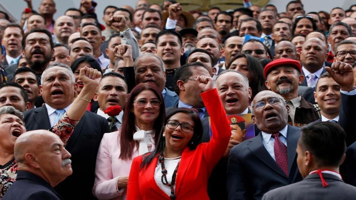 Constituent Assembly President Delcy Rodríguez, front and center, leads newly sworn-in delegates as they pose for an official portrait Friday.