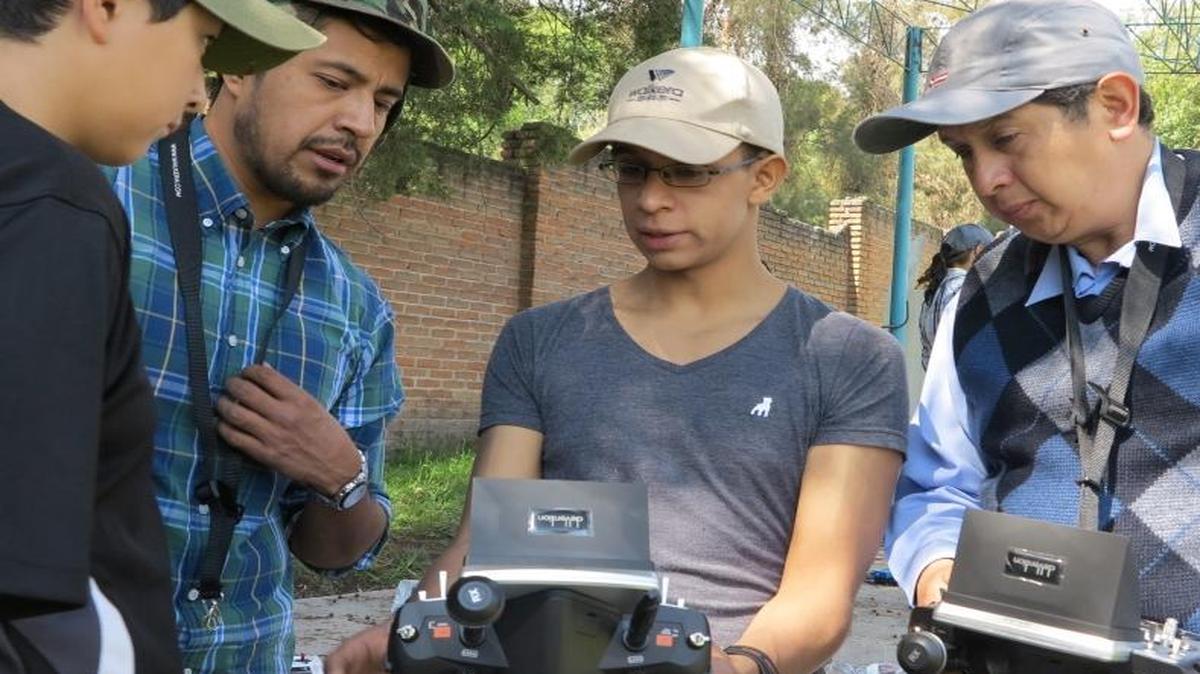 
A trainer at Mexico City’s Drone Academy, Fernando Lina, center left, shows students techniques for using a remote control during a field session Aug. 16, 2015. 
