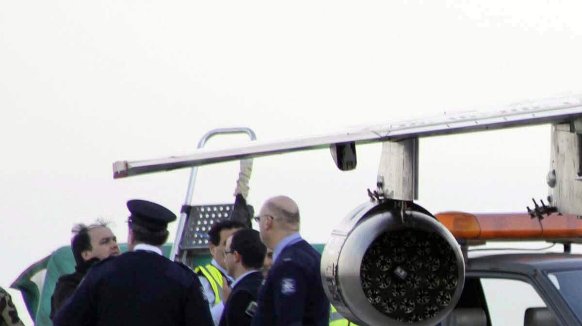 The pilot of one of two Libyan air force jets, right, stands next to his plane Monday at Malta's International airport. The pilots asked for political asylum.