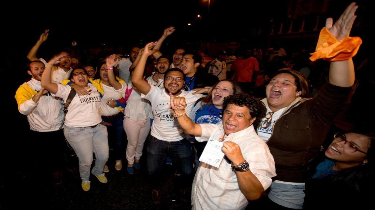 Opposition supporters celebrate in Caracas, Venezuela, early Monday, Dec. 7, 2015. Venezuela’s opposition has won control of the National Assembly by a landslide.