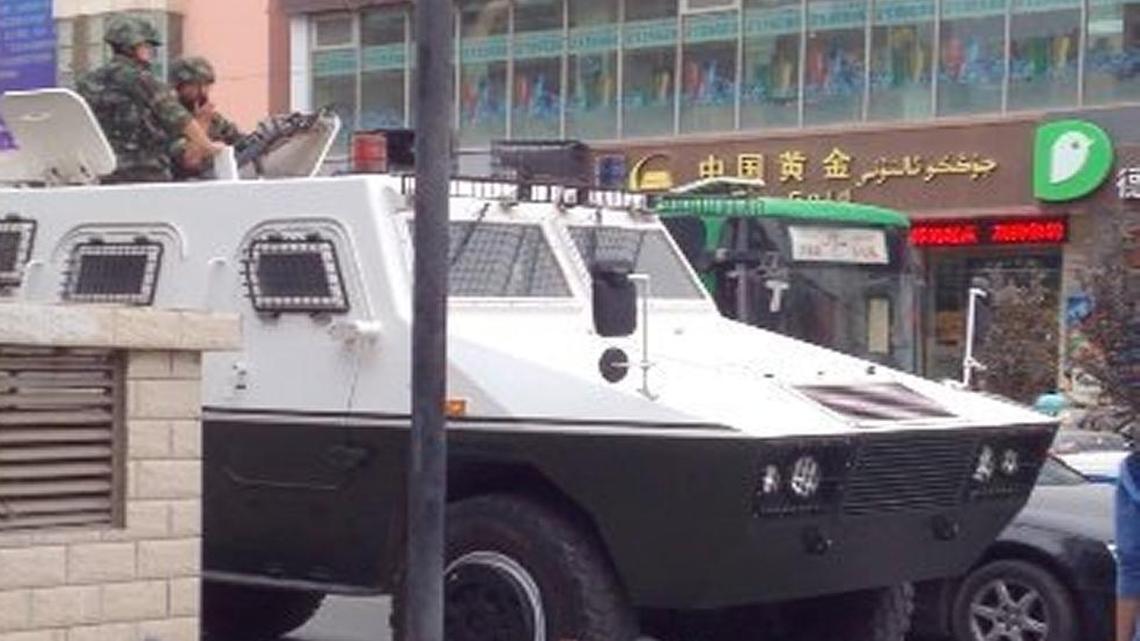 Chinese police with guns in an armored vehicle rumble through Aksu, a city in Xinjiang province, China, on July 29, 2015. Clashes between Chinese authorities and Muslim Uighurs, who resent Beijing's rule, have killed hundreds in this part of far-western China in recent years.