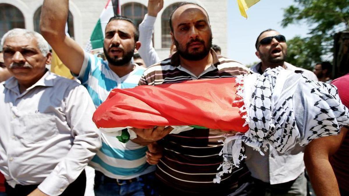 
The body of 18-month-old Palestinian Ali Dawabsheh, who was killed after his family's house was set on fire in a suspected attack by Jewish extremists, is carried during his funeral Friday, July 31, 2015, in Duma village near the West Bank city of Nablus. 
