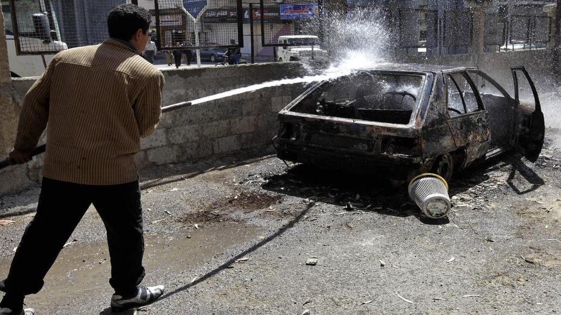 A Syrian municipality worker sprays water on a car that was set on fire by Syrian anti-government protesters, in the southern city of Daraa, Syria, on March 21, 2011. Mourners chanting "No more fear!" have marched through a Syrian city where anti-government protesters had deadly confrontations with security forces in recent days. The violence in Daraa, a city of about 300,000 near the border with Jordan, was fast becoming a major challenge for President Bashar Assad, who tried to contain the situation by freeing detainees and promising to fire officials responsible for the violence.