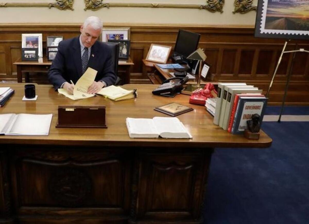 Vice President-elect Mike Pence signs off on paperwork sending Indiana's electors to the electoral college at the Statehouse Friday, Dec. 2, 2016, in Indianapolis.
