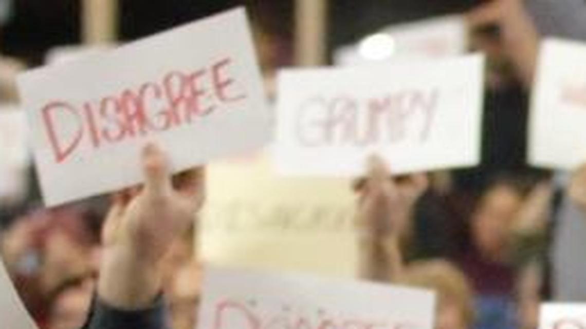 In this Thursday, Feb. 9, 2017, file photo, people react as U.S. Rep. Jason Chaffetz speaks during a town hall meeting at Brighton High School in Cottonwood Heights, Utah. Some attendees of the contentious town hall hosted by Chaffetz have sent the congressman fake invoices after he claimed some people there were paid protesters.