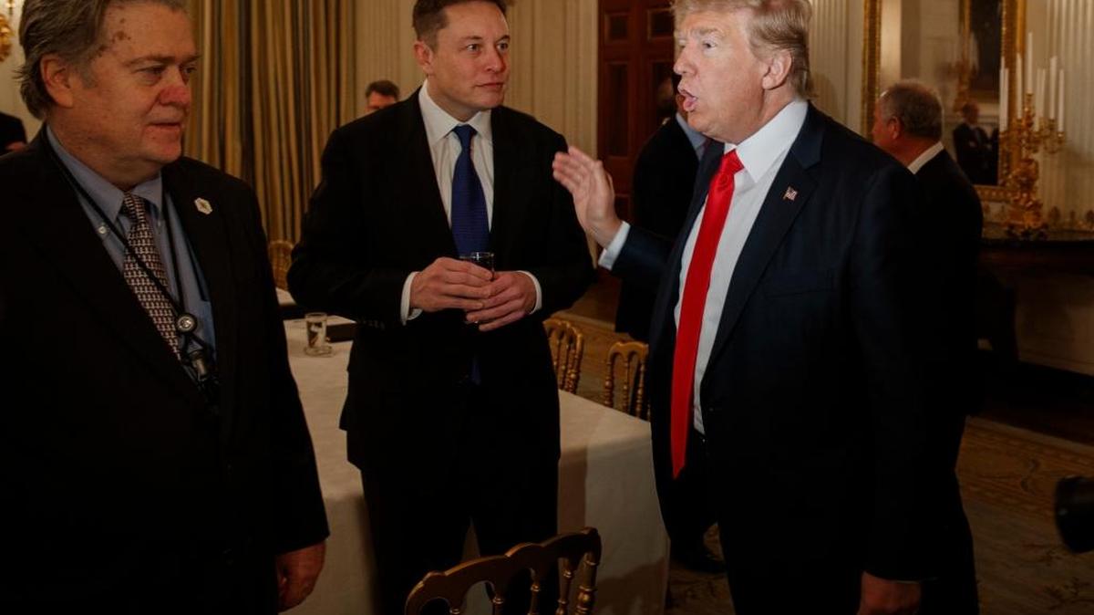 President Donald Trump talks with Tesla and SpaceX CEO Elon Musk, center, and White House chief strategist Steve Bannon during a meeting with business leaders at the White House.
