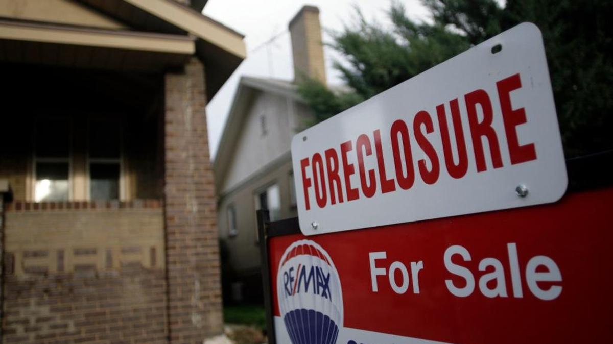 A foreclosure sign tops a sale sign outside an existing home on the market in Denver in this Aug. 29, 2007 file photo.