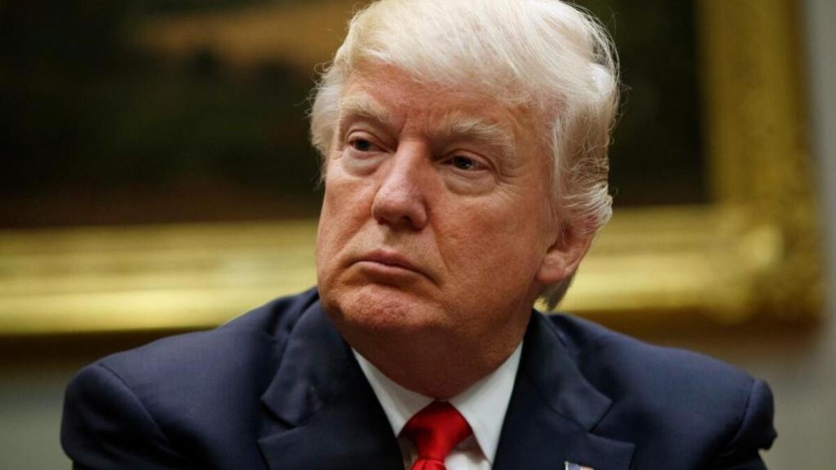 In this March 31, 2017, photo, President Donald Trump listens during a meeting with the National Association of Manufacturers in the Roosevelt Room of the White House in Washington. Slim majorities of Americans favor independent investigations into Trump’s relationship with the Russian government and possible attempts by Russia to influence last year’s election according to a new poll by The Associated Press-NORC Center for Public Affairs Research.