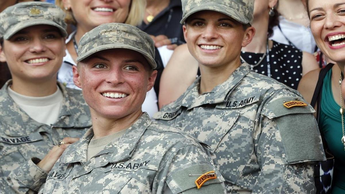 U.S. Army First Lt. Shaye Haver, center, and Capt. Kristen Griest, right, pose for photos with other female West Point alumni after an Army Ranger school graduation ceremony, Friday, Aug. 21, 2015, at Fort Benning, Ga. Congress is still divided over the issue of having women register for the draft.