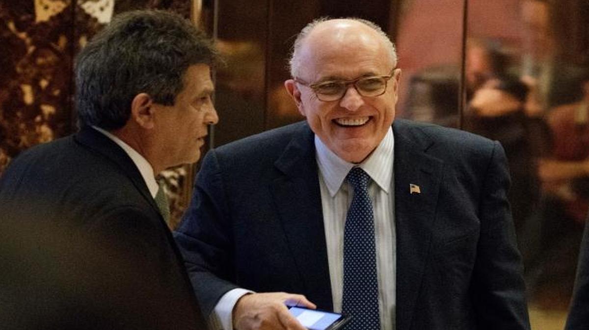 Former New York Mayor Rudy Giuliani, center, smiled as he left Trump Tower Friday. He’s proud of his work on behalf of the Iranian exile group, Mujahedin-e Khalq.