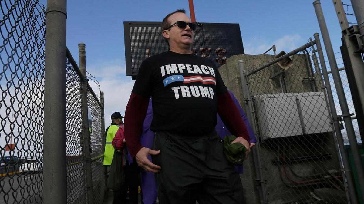 Pat Waters wears a shirt that reads Impeach Trump after he participated in Bridge Together Golden Gate, a demonstration and performance art piece against the inauguration of President Donald Trump, on the Golden Gate Bridge in San Francisco, Friday, Jan. 20, 2017.