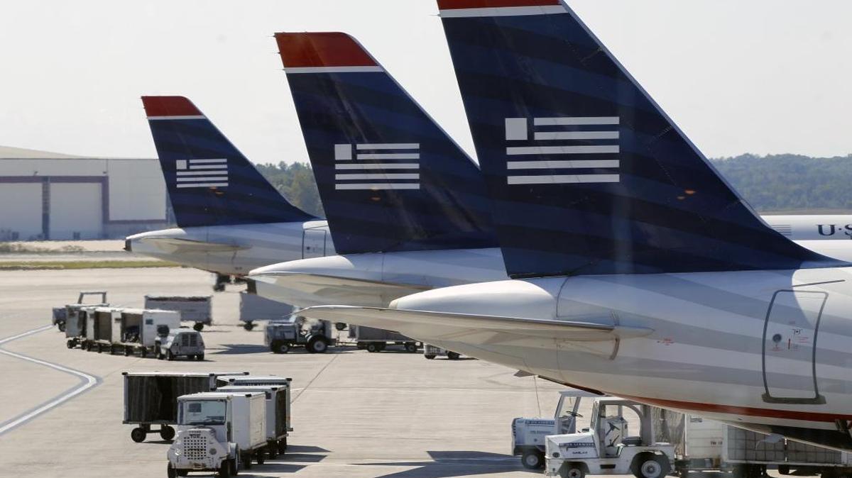 US Airways jets are parked at their gates at the Charlotte-Douglas International Airport prior to the carrier’s merger with American Airlines. A bill in Congress would remove air traffic control from the Federal Aviation Administration and transfer it to a new independent, private entity.
