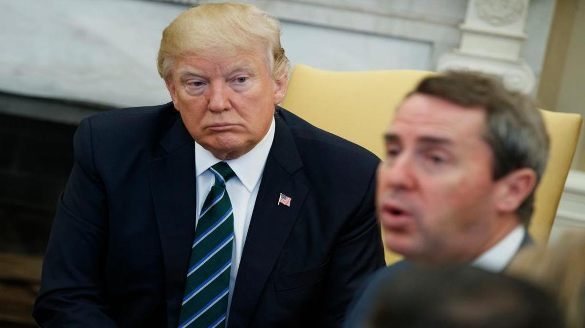 FILE – President Donald Trump listens as U.S. Rep. Mark Walker, R-N.C., speaks during a health care policy meeting with the Republican Study Committee, Friday, March 17, 2017, in the Oval Office of the White House in Washington.